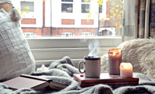 Cozy home. Candles, book and a cup of tea