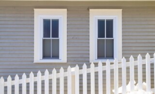 two double-hung windows behind a picket fence
