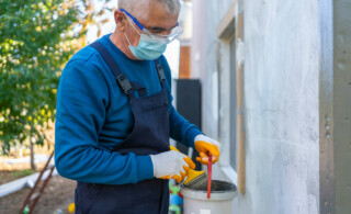 man painting home exterior