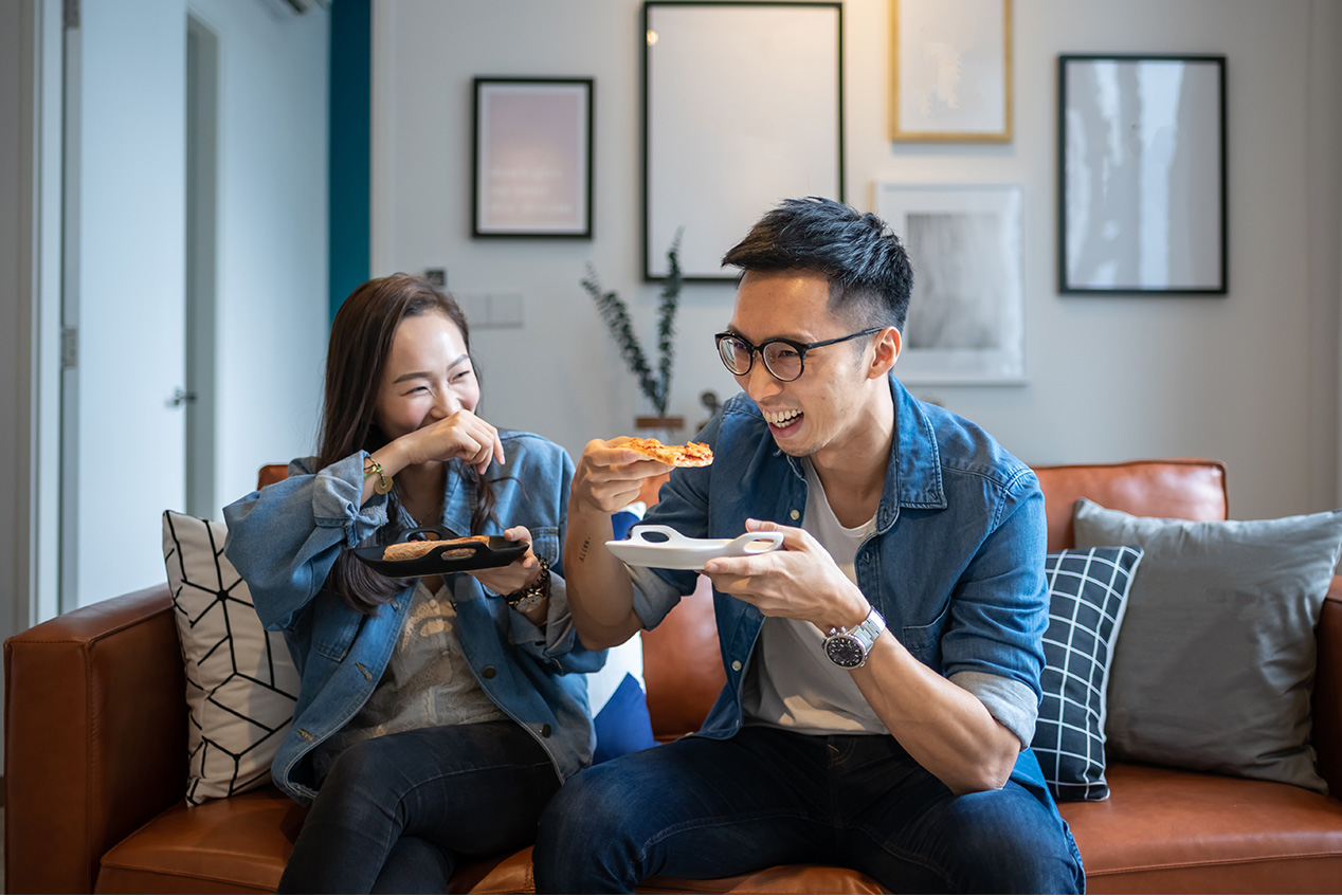 couple eating pizza on couch